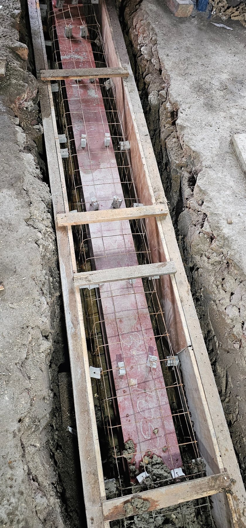 Reinforcement and steel beam prepared within a new foundation