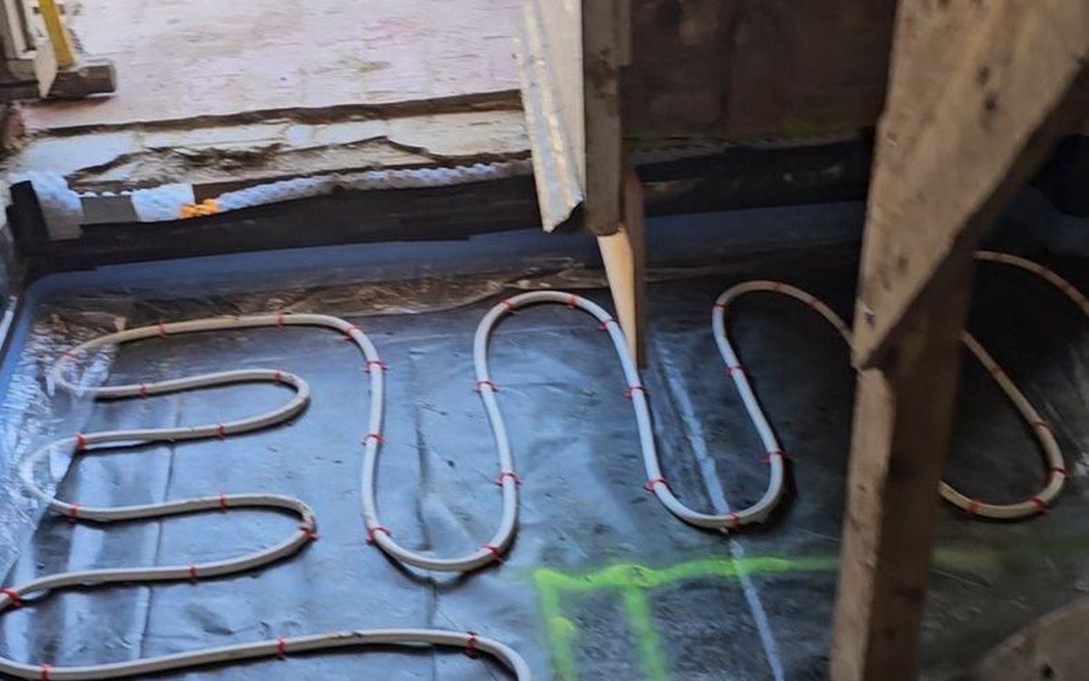 Underfloor heating installation over a waterproofing system